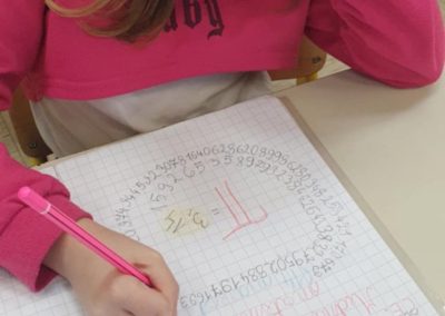 Fotografija učenke, ki ureja zvezek s številom pi.